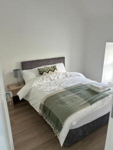 a bedroom with a large bed with a gray headboard at A Village Gem in Mullingar