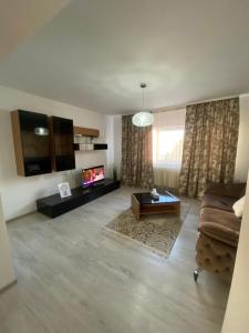 a living room with a couch and a tv at Apartament SUN in Drăgăşani