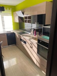 una cocina con electrodomésticos de acero inoxidable y paredes amarillas en Apartament SUN en Drăgăşani