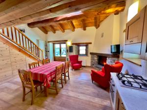 a kitchen and dining room with a table and chairs at La Mizoùn de Marguerito - Appartamento Rododendro in Acceglio