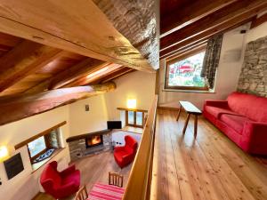 a living room with a red couch and a fireplace at La Mizoùn de Marguerito - Appartamento Rododendro in Acceglio