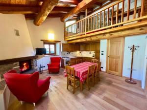 a living room with a table and chairs and a fireplace at La Mizoùn de Marguerito - Appartamento Rododendro in Acceglio +4 photos