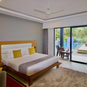 a bedroom with a bed and a view of a pool at The Upper House resort by J R high Sky in Morjim