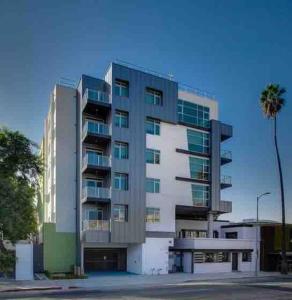 a tall building with a palm tree in front of it at Designer Hollywood Penthouse with Private Balcony on Sunset in Los Angeles