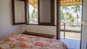 a bedroom with a bed and a window with a view at Casa Pé na Areia Taipu de Fora 400m Piscinas Naturais in Barra Grande