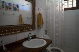 a bathroom with a sink and a mirror and a toilet at Casa Pé na Areia Taipu de Fora 400m Piscinas Naturais in Barra Grande +31 photos
