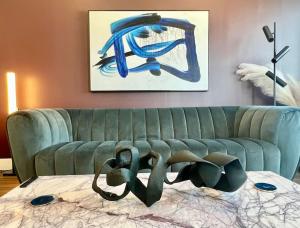 a living room with a green couch and a painting at Designer Hollywood Penthouse with Private Balcony on Sunset in Los Angeles