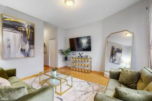 a living room with a couch and a glass table at Chic Green l Near Downtown & IL Medical District in Chicago