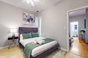 een slaapkamer met een bed met twee handdoeken erop bij Chic Green l Near Downtown & IL Medical District in Chicago