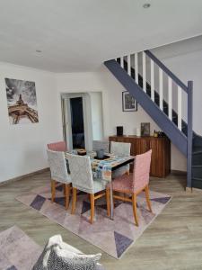 a dining room with a table and chairs and a staircase at duplex spacieux Jo24 proche Paris et stade de France in Drancy
