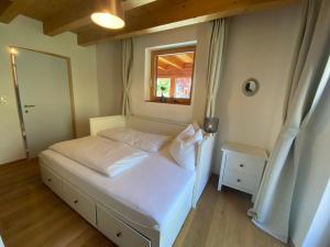 um quarto com uma cama branca e uma janela em Chalet Ida em Haiming