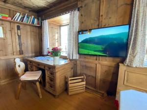 um quarto com uma televisão, uma mesa e uma cadeira em Chalet Ida em Haiming