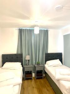 a bedroom with two beds and a window with a curtain at Furnished 1 bedroom apartment in Bristol