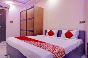 a bedroom with a large bed with red pillows at OYO Flagship Hotel Classic Square in Pune