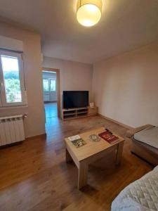 a living room with a table and a tv at Maravillosas vistas 