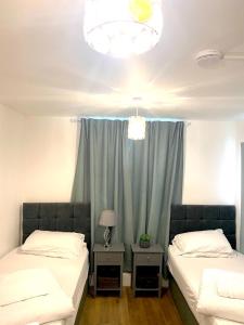 sypialnia z 2 łóżkami i oknem z niebieską zasłoną w obiekcie Furnished 1 bedroom apartment w Bristolu