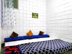 Habitación con sofá y almohadas. en Mannat Inn TS Mysore - Premium Homestay, en Mysore