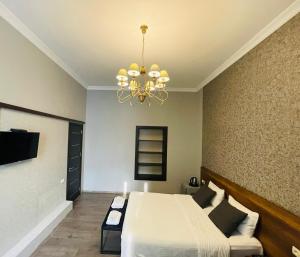 um quarto com uma cama e um lustre em 2nd Floor Hotel em Tbilisi