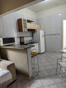 a kitchen with a counter and a refrigerator at Casa de família e Quarto in Balneário Camboriú