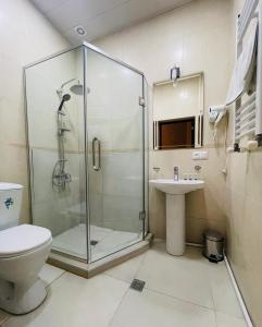 uma casa de banho com um chuveiro, um WC e um lavatório. em 2nd Floor Hotel em Tbilisi