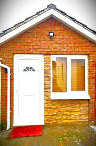 una casa de ladrillo con una puerta blanca y una ventana en Mountain lodge, en Dundalk