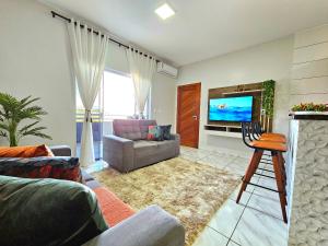 - un salon avec un canapé et une télévision dans l'établissement Lindo APT, prox Paraguai com Churrasqueira, à Foz do Iguaçu