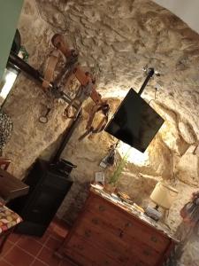 ein Wohnzimmer mit einem TV an einer Steinmauer in der Unterkunft CASA Flag Tur in Castel del Monte