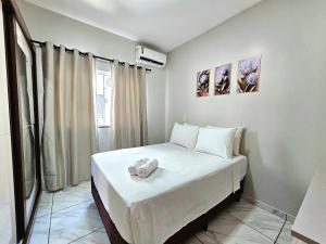 Cette petite chambre comprend un lit avec des draps blancs. dans l'établissement Lindo APT, prox Paraguai com Churrasqueira, à Foz do Iguaçu