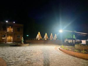 um parque de estacionamento à noite com uma estátua e edifícios em Villaggio dos Vinhedos em Bento Gonçalves