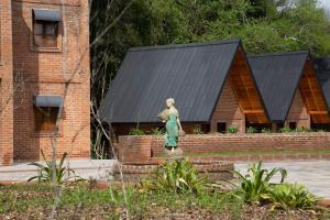 本圖貢薩爾維斯的住宿－Villaggio dos Vinhedos，砖房前的女人雕像