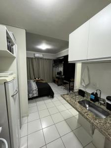 a kitchen with a sink and a room with a bed at Travellar Spot 313B in Ribeirão Preto
