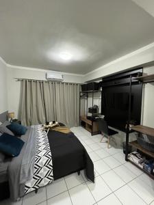 a bedroom with a bed and a desk and a television at Travellar Spot 313B in Ribeirão Preto