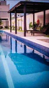 a swimming pool with a gazebo and blue water at Travellar Spot 313B in Ribeirão Preto