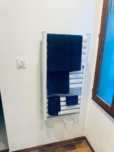 um toalheiro na casa de banho com toalhas azuis em Le green touch em Bourges