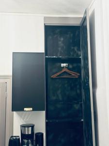 um armário preto com um cabide numa cozinha em Le green touch em Bourges