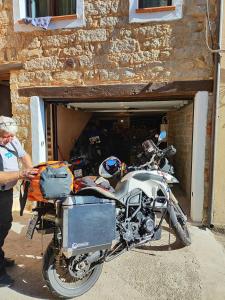 a man standing next to a motorcycle in a garage at Antico Restauro in Fonni