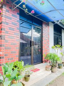 une porte d'entrée d'une maison avec des plantes en pot dans l'établissement Dusun Indah Cottage 2, à Bayan Lepas