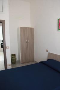 1 dormitorio con 1 cama azul y armario de madera en Casa corrado, en Sarno