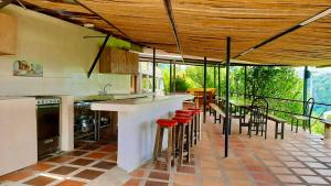 a kitchen with a bar and a table and chairs at Mountain View Hostel in Manizales