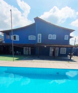 um edifício azul com uma piscina em frente em Pousada Genesis Guaruja no Guarujá