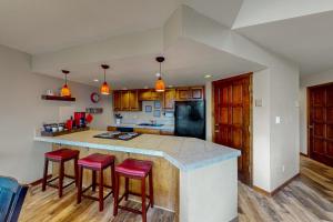 a kitchen with a counter and stools in a room at Purgatory Perch in Durango Mountain Resort