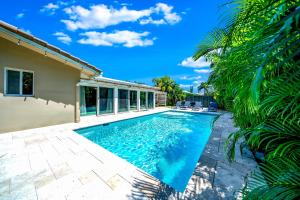 uma piscina no quintal de uma casa com palmeiras em Paradise (Pool, Beach & Billiards) em Deerfield Beach