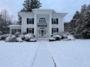 een wit huis met een met sneeuw bedekte oprit bij Entertainer's Luxury Retreat in Thomaston