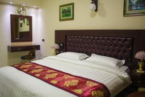 una camera con un grande letto e uno specchio di Qaser Al-Sultan Hotel Suites ad Amman