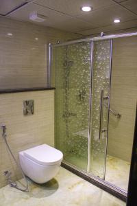 e bagno con doccia, servizi igienici e box doccia in vetro. di Qaser Al-Sultan Hotel Suites ad Amman