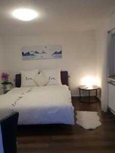 a bedroom with a white bed and a table at FeWo Goslar Harz in Goslar