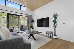 een woonkamer met een bank en een tafel bij Serenity on Sophia in Rotorua