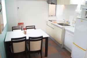 cocina con mesa, sillas y fregadero en Space Air Building 3F - Vacation STAY 11441, en Tokio
