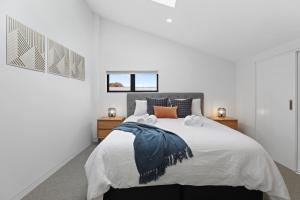 a bedroom with a large bed with two towels on it at Serenity on Sophia in Rotorua