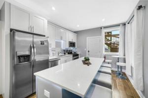 a kitchen with a white counter and a stainless steel refrigerator at Spacious Haven 8-Min to Chicago Sleeps 10 in Forest Park